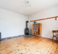 Interior of a family house with a stove, a display cabinet, and a wooden decor floor.