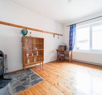 Interior of a family house with a fireplace, display cabinet, and wooden decor flooring.