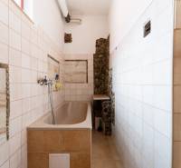 Bathroom in a family house with tiles and a bathtub, decorative stones on the walls.