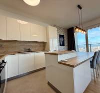 A kitchen with a wood-patterned floor and a panoramic view in a 3-room apartment.