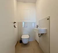 Bathroom with toilet and sink in a 3-room apartment, light tiles and flooring.