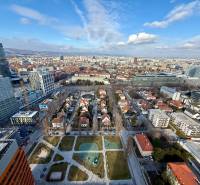 A view of the Bratislava skyline with contemporary architecture, greenery, and sports facilities.