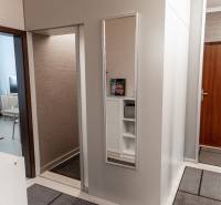 Entrance hall in a 4-room apartment with wood-patterned flooring and a mirror.
