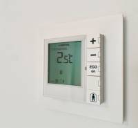 Wall thermostat with display in a 2-room apartment for temperature regulation.