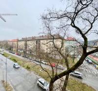 A view of the winter Košická Street in Bratislava, lined with trees and cars.