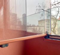 A glazed loggia of a 2-room apartment with a view of the district in Bratislava.