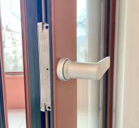 Detail of a metal door handle in a 2-room apartment with a view outside.