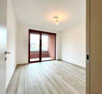 A room in a 2-room apartment with a balcony and a floor with a wood decor.