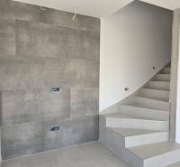 A staircase in a family house with tiles and a wall with ceramic cladding.