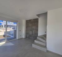 Interior of a family house with tiles and a staircase, view of the street.