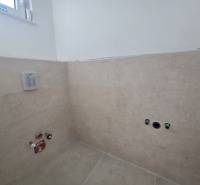 A family house bathroom with installations, tiles, and neutral colors.