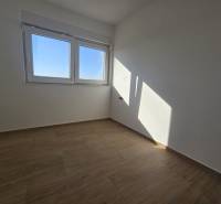 A room in a family house with a minimalist design and a wooden decor floor.