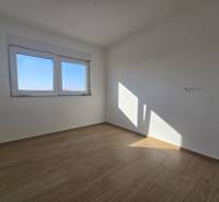 A room in a family house with a large window and a wooden decor floor.