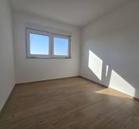 A room with a wooden floor decor in a family house, light walls, and a window.