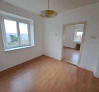 A room with white walls and a wooden decor floor in a family house.