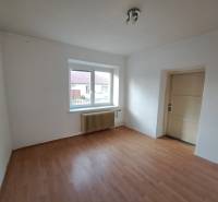 A room in a family house with white walls and a wooden decor floor.
