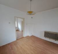A room with white walls and a wooden decor floor in a family house.