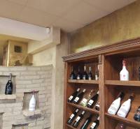 Shelving racks with wine and a decorative brick wall in commercial premises.