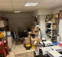 Commercial space with cardboard boxes, furniture, and shelves, wooden decor flooring.