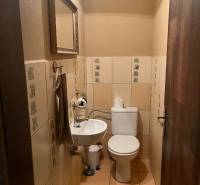 A restroom with a sink, mirror, and ceramic tiles in commercial premises.