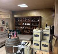 Commercial space with a sofa, a barrel, and a shelf full of wine bottles.