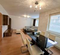 Dining and living area of a 3-room apartment with a wooden decor floor.