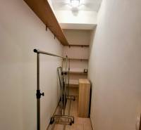 Storage space in a 3-room apartment with shelves and clothing racks.