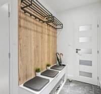 Entrance hall in a family house with a coat rack and seating with a wooden decor.