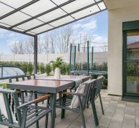 Terrace of a family house in Dunajský Klátov with a seating area, covered swimming pool, and trampoline.