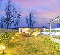 The garden of a family house in Dunajský Klátov with lighting, a swimming pool, and a shelter.