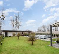 A garden at a family house in Dunajský Klátov with a gazebo and a covered swimming pool.