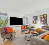 Living room of a family house with a wooden decor floor, decorative pictures, and comfortable seating.