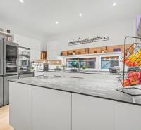 A kitchen in a family house with equipment: refrigerator, stove, and floor with wood decor.