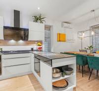 A kitchen in a family house with furnishings and a dining table, a floor with a wooden decor.