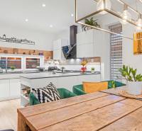 A kitchen in a family house with a wooden dining table and decoration on the shelf.