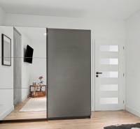 Bedroom in a family house with a built-in wardrobe and a floor with a wood decor.