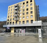 A building with commercial spaces on Prostějovská Street in Prešov under the blue sky.