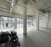 Spacious commercial spaces with large windows and concrete flooring.