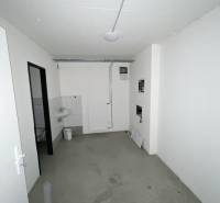 Commercial space with gray flooring, a sink, and white walls.