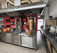 A kitchen of gastro premises with grilling equipment and stainless steel counters.