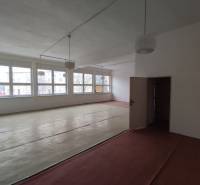 A room in offices with large windows and a wooden decor floor.