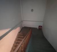 Interior of an office with a staircase and wooden railing.