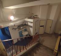 Offices with a staircase and a sink, floor with wood decor, storage space.