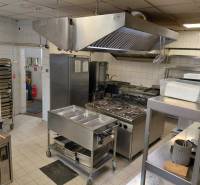 Professional kitchen with stainless steel appliances and equipment in catering spaces.