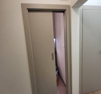 Sliding doors in a 2-room apartment with a wood-patterned floor.