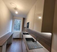 A new kitchen in a 2-room apartment with a wood-patterned floor and modern equipment.