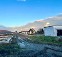 Residential building plots on Poľnohospodárska Street in Trenčín with unfinished houses.