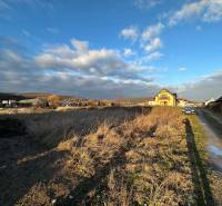 Plots - housing on Poľnohospodárska Street in Trenčín, with a visible family house and road.
