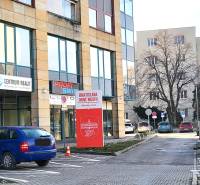 Commercial premises on Vajnorská Street in Bratislava - Nové Mesto with cars in the parking lot.