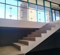 Interior of commercial spaces with glass walls and a staircase.